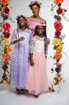 African-American mother and daughters wearing flowers and dresses