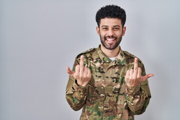 Arab man wearing camouflage army uniform showing middle finger doing fuck you bad expression, provocation and rude attitude. screaming excited