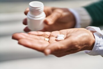 Middle age woman holding pills at street