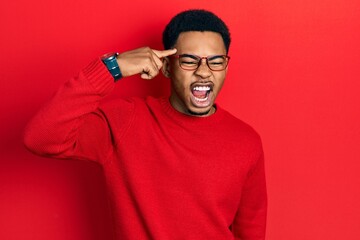 Fototapeta premium Young african american man pointing head with finger angry and mad screaming frustrated and furious, shouting with anger. rage and aggressive concept.