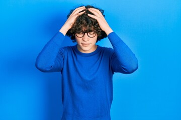 Handsome young man wearing casual clothes and glasses suffering from headache desperate and...