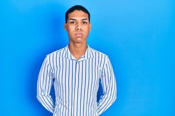 Young african american guy wearing casual clothes puffing cheeks with funny face. mouth inflated...