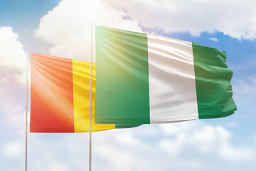 Sunny blue sky and flags of nigeria and guinea - obrazy, fototapety, plakaty