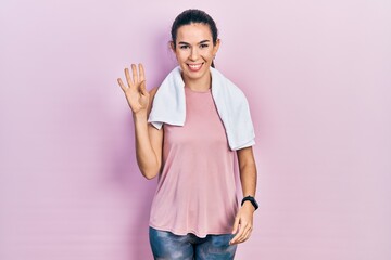Young brunette woman wearing sportswear and towel showing and pointing up with fingers number five...