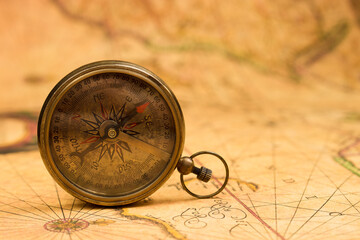 Fototapeta na wymiar Old compass on vintage map. Adventure retro style