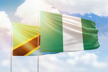 Sunny blue sky and flags of nigeria and tanzania