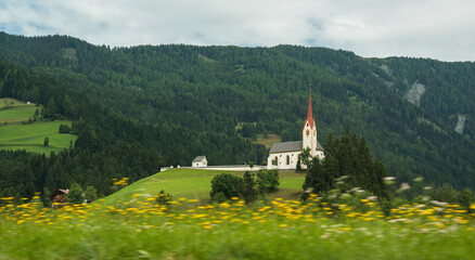 Church in the Dolomites mountains on a summer cloudy day