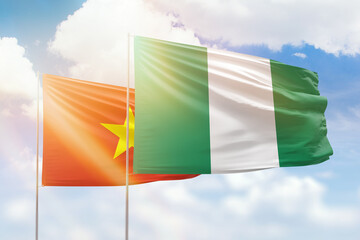 Sunny blue sky and flags of nigeria and vietnam