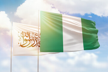 Sunny blue sky and flags of nigeria and afghanistan