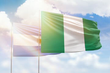 Sunny blue sky and flags of nigeria and argentina