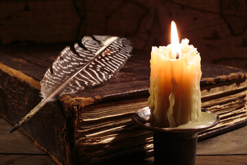 Lighting candle near ancient book. Vintage retro still life style