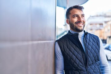 Young hispanic man smiling confident standing at street