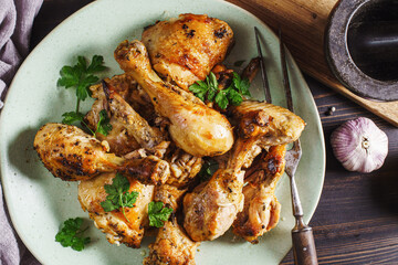 Chicken drumsticks on plate, top view