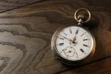 Old vintage pocket watch on wooden background