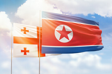 Sunny blue sky and flags of north korea and georgia