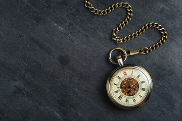 Antique clock and chain on a stone background