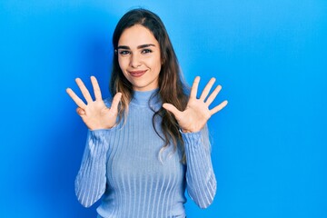 Young hispanic girl wearing casual clothes showing and pointing up with fingers number nine while...