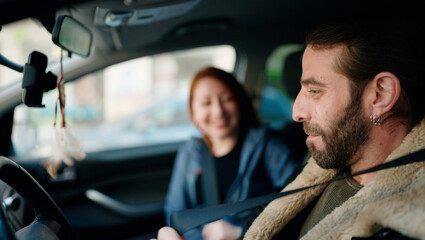 Man and woman couple smiling confident driving car at street