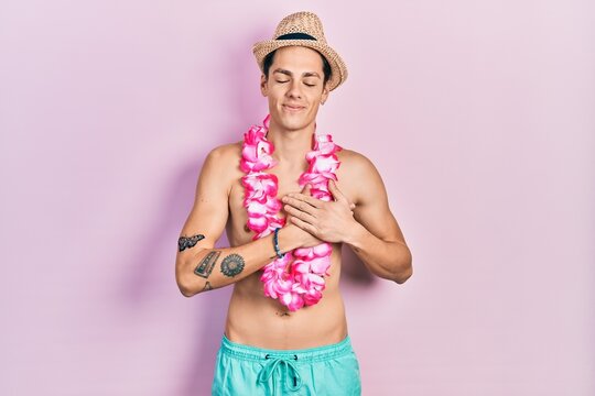 Young hispanic man wearing swimwear and summer hat smiling with hands on chest, eyes closed with grateful gesture on face. health concept.