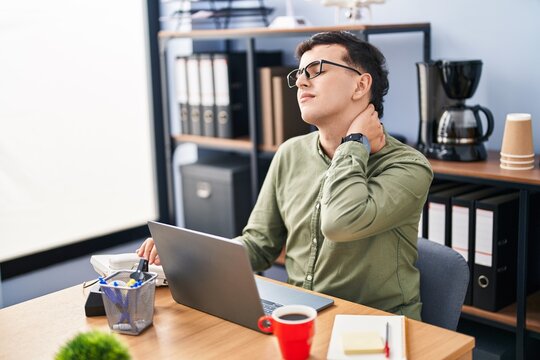 Young non binary man business worker stressed suffering for neck ache at office