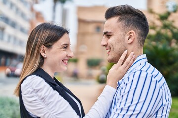 Man and woman couple smiling confident hugging each other at park