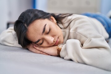 Young hispanic woman lying on sofa sleeping at home