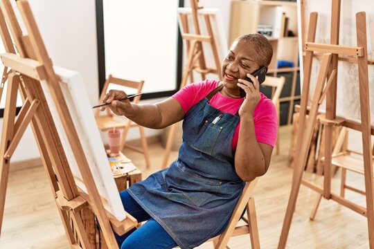 Senior african american woman talking on the smartphone drawing at art studio