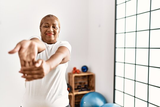 Senior african american woman smiling confident training using grip hand at sport center