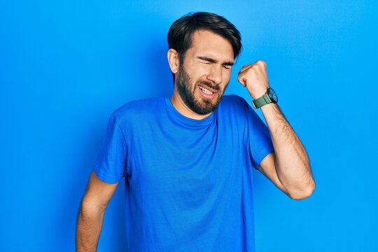 Young hispanic man wearing casual clothes stretching back, tired and relaxed, sleepy and yawning for early morning