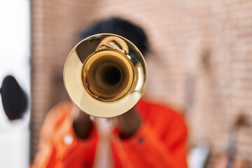 African american man musician playing trumpet at music studio