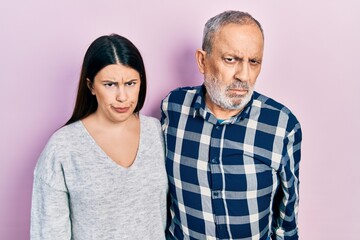 Hispanic father and daughter wearing casual clothes skeptic and nervous, frowning upset because of problem. negative person.