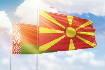 Sunny blue sky and flags of north macedonia and belarus