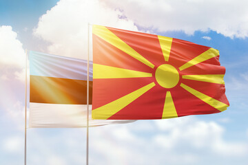 Sunny blue sky and flags of north macedonia and estonia