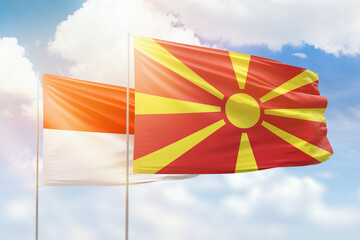 Sunny blue sky and flags of north macedonia and indonesia