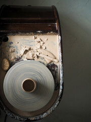 A clay pot on a pottery wheel.A day in the life of a pottery artist - at the pottery workplace. Pottery craft.View from above.