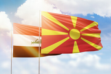 Sunny blue sky and flags of north macedonia and iraq