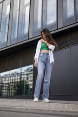 A girl in casual clothes walks in the city center. Beautiful life.