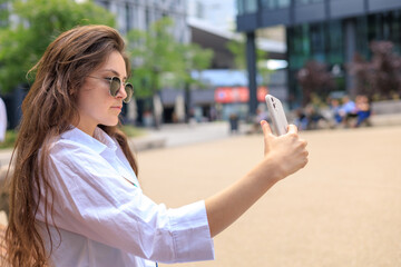 Girl in sunglasses takes a selfie.