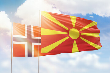 Sunny blue sky and flags of north macedonia and norway