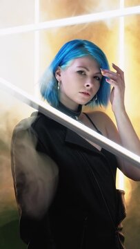 Techno style. Cyberpunk futurism. Generation Z. Futuristic fashion woman model posing in smoke effect LED lamp light studio background vertical.