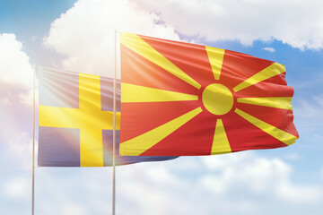 Sunny blue sky and flags of north macedonia and sweden
