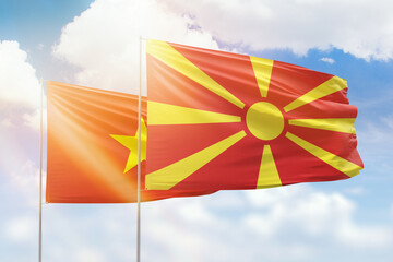 Sunny blue sky and flags of north macedonia and vietnam