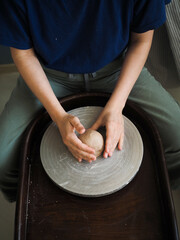 Ceramist young woman preparing clay to make pottery pieces in her studio; anonymous hands at work. Small business, hobby, ceramic concept.