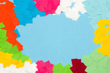 pastel blue background as copy space surrounded by colorful papers, creative summer design