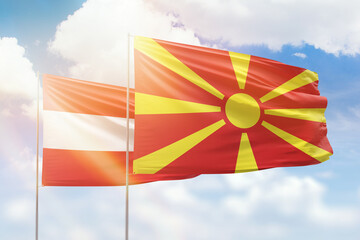 Sunny blue sky and flags of north macedonia and austria