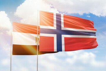 Sunny blue sky and flags of norway and egypt