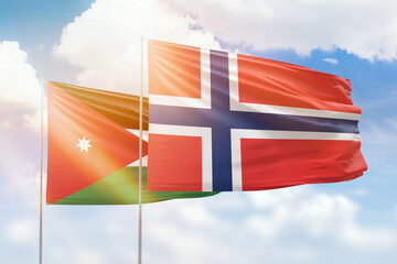 Sunny blue sky and flags of norway and jordan