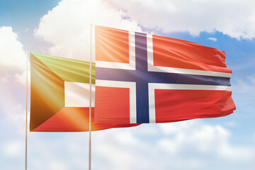 Sunny blue sky and flags of norway and kuwait