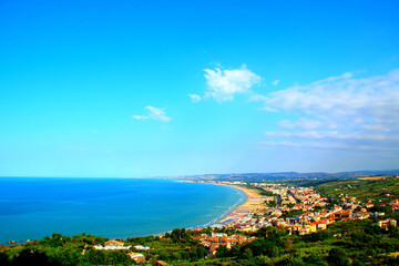 Fototapeta na wymiar Impressive panorama from the Vasto town in Abruzzo region with peaceful green land descending to the populated coastline washed by the serene blue waters of the Adriatic Sea on a fine summer day