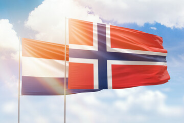 Sunny blue sky and flags of norway and netherlands